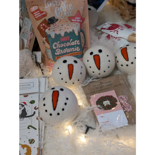 White ceramic snowman dryer balls with carrot noses and black eyes