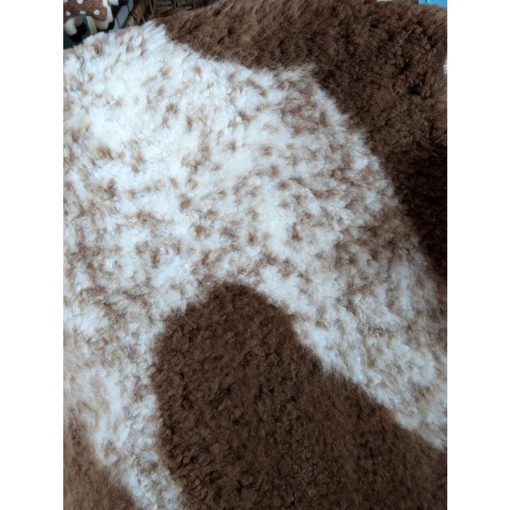 A plush fluffy grade a- sheepskin blanket with soft white and brown tibet highland spotted pattern