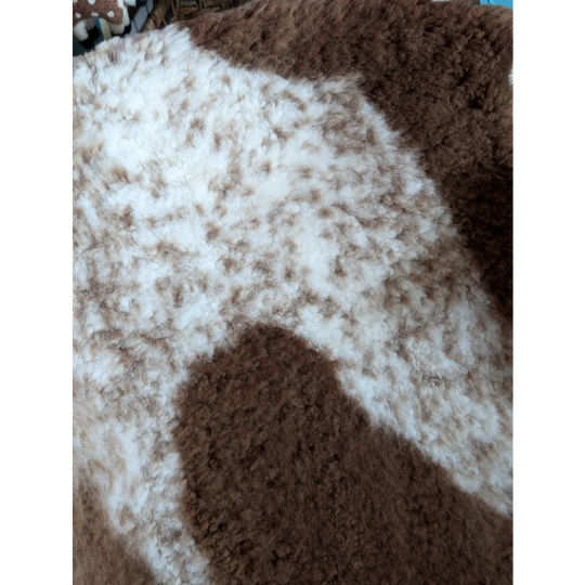 A plush fluffy grade a- sheepskin blanket with soft white and brown tibet highland spotted pattern