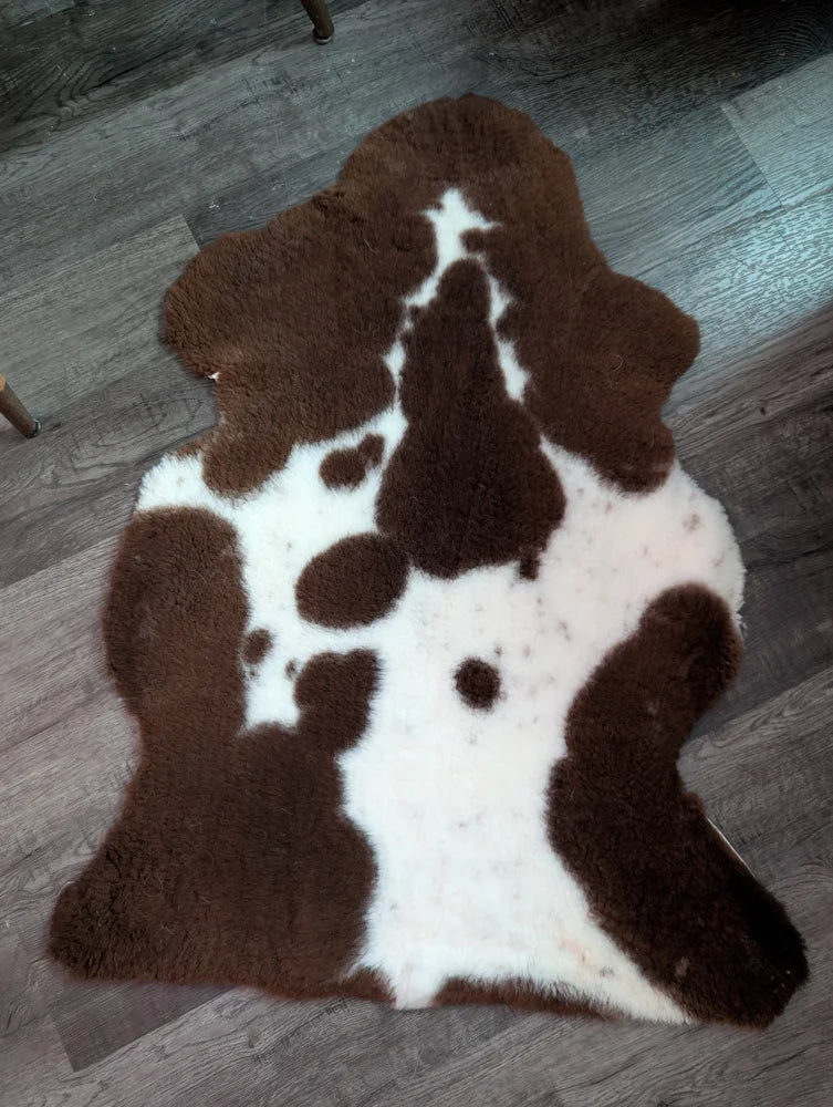 Brown and white highland spotted grade b sheepskin rug with plush furry texture perfect for cozy spaces