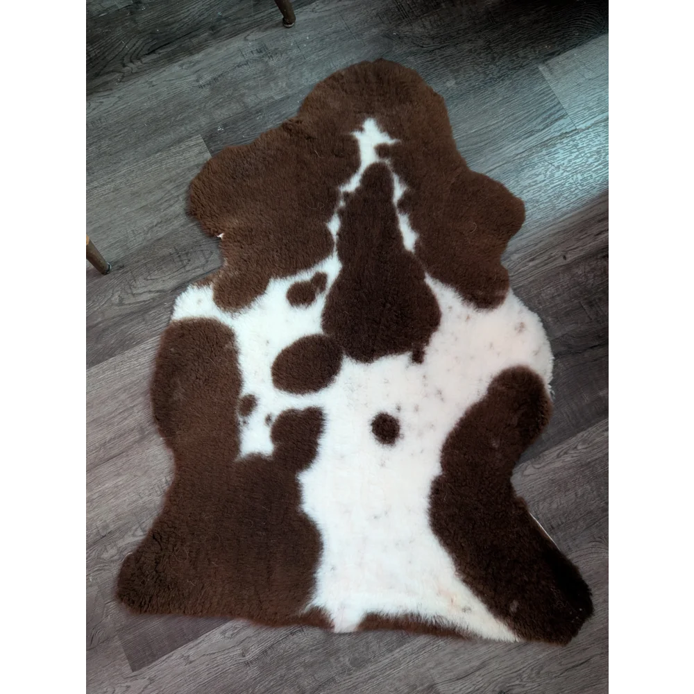 Brown and white highland spotted grade b sheepskin rug with plush furry texture perfect for cozy spaces