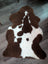 Brown and white highland spotted grade b sheepskin rug with plush furry texture perfect for cozy spaces