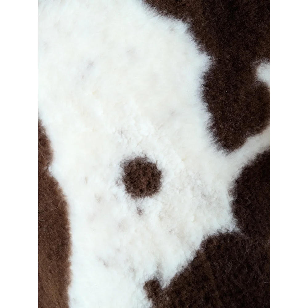 A plush fuzzy brown and white highland spotted grade b sheepskin sweater perfect for cozy wear