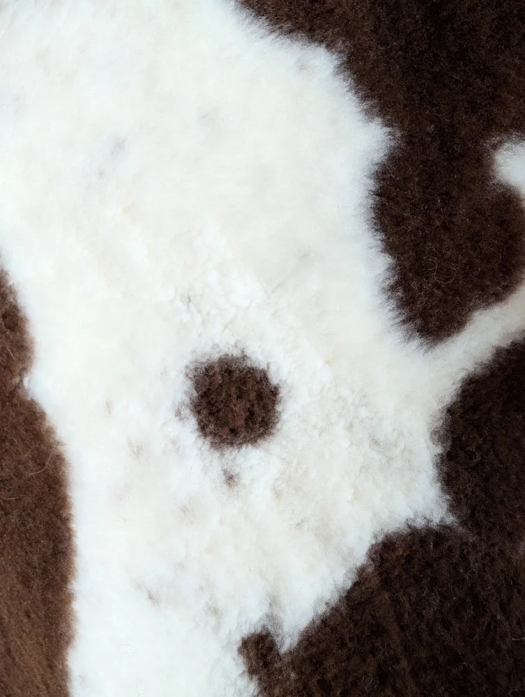 A plush fuzzy brown and white highland spotted grade b sheepskin sweater perfect for cozy wear