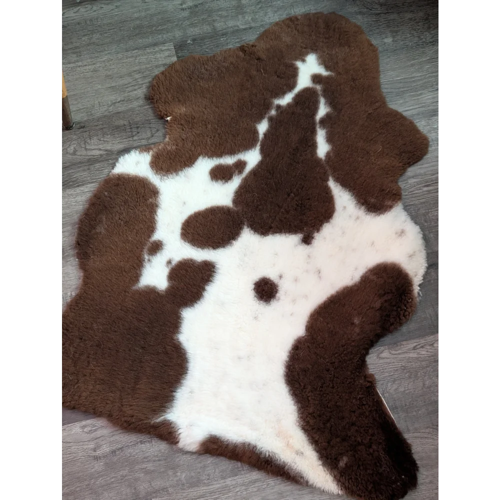 Brown and white highland spotted grade b sheepskin rug with plush fluffy texture perfect for cozy decor