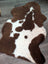 Brown and white highland spotted grade b sheepskin rug with plush fluffy texture perfect for cozy decor