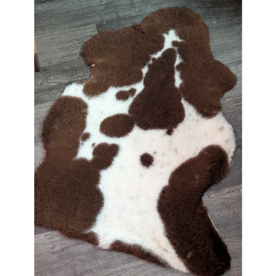 Brown and white highland spotted grade b sheepskin rug with plush fluffy texture perfect for cozy decor