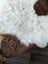 A plush curly white and brown tibet highland spotted grade a- sheepskin rug with soft fluffy texture