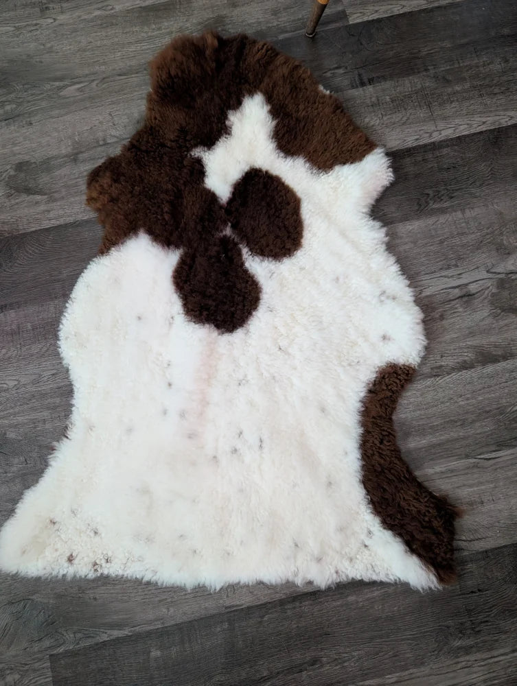 A plush tibet highland spotted grade a- sheepskin rug in white and brown cow print natural fur perfect for cozy decor