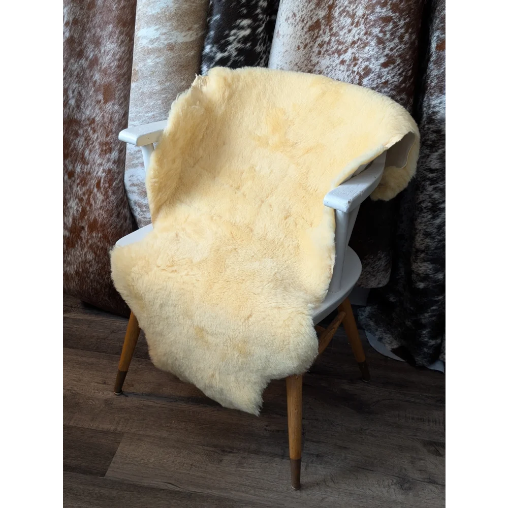 Cozy cream shearling wool medical sheepskin rug with wooden legs, boosts blood flow