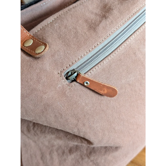 Dusty rose oakley specks canvas bag with spacious design and real cowhide leather zipper pull and strap accents