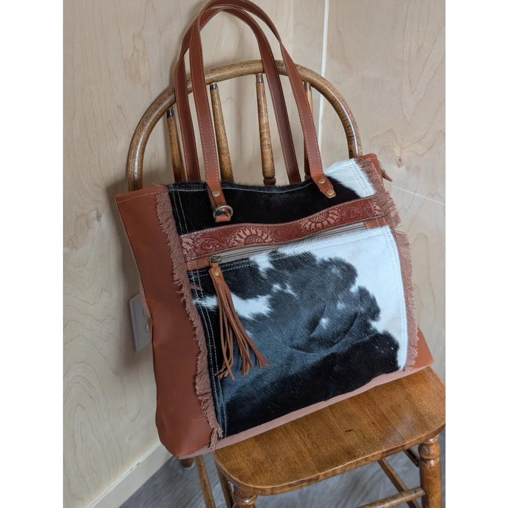 Brown leather oakley bag with real cowhide patch, frayed edges, embossed strap, and spacious design