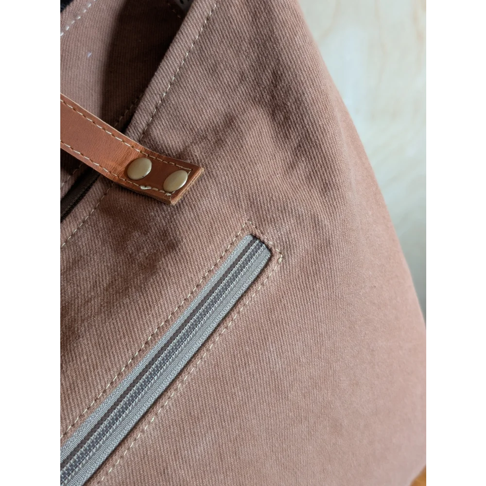 A taupe oakley specks canvas tote bag with brown real cowhide strap and brass rivets perfect spacious bag