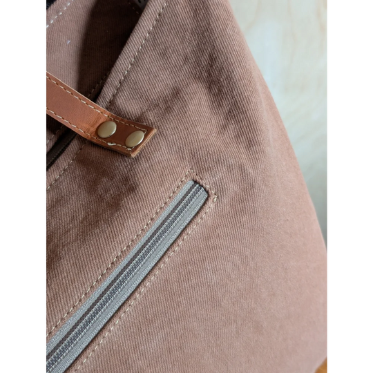 A taupe oakley specks canvas tote bag with brown real cowhide strap and brass rivets perfect spacious bag
