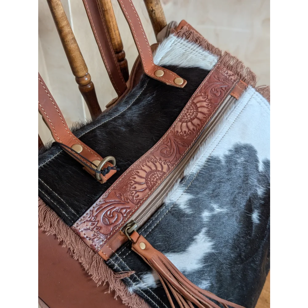 A brown leather oakley bag strap with real cowhide, sunflower embossing, brass hardware, and fringed edges