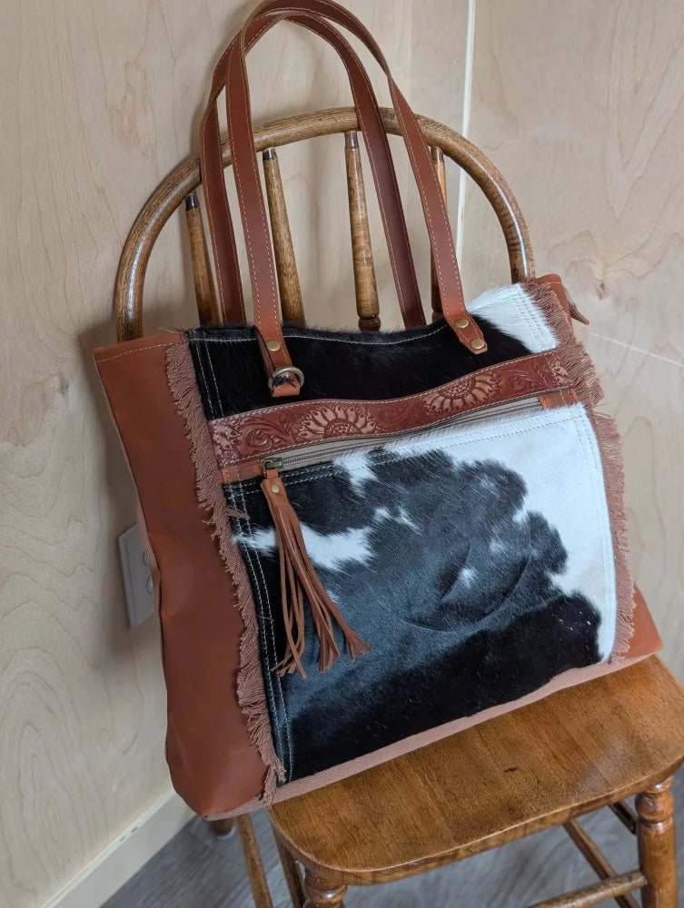 Brown leather oakley bag with real cowhide patch, frayed edges, embossed strap, and spacious design