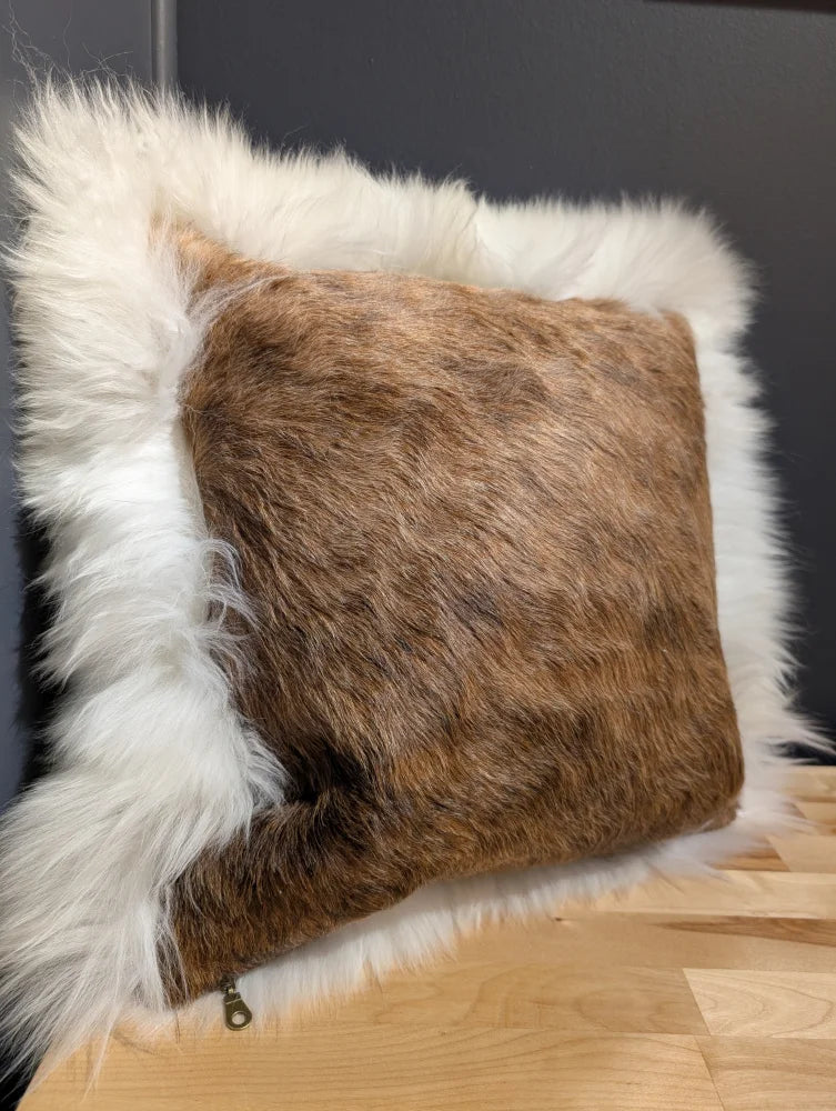 A cozy square cowhide merino sheepskin cushion with brown textured fur and plush white faux-fur border