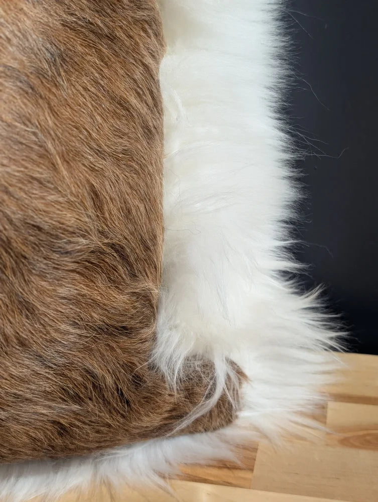 Brown and white faux fur cowhide merino sheepskin cushion with plush textured surface for cozy decor