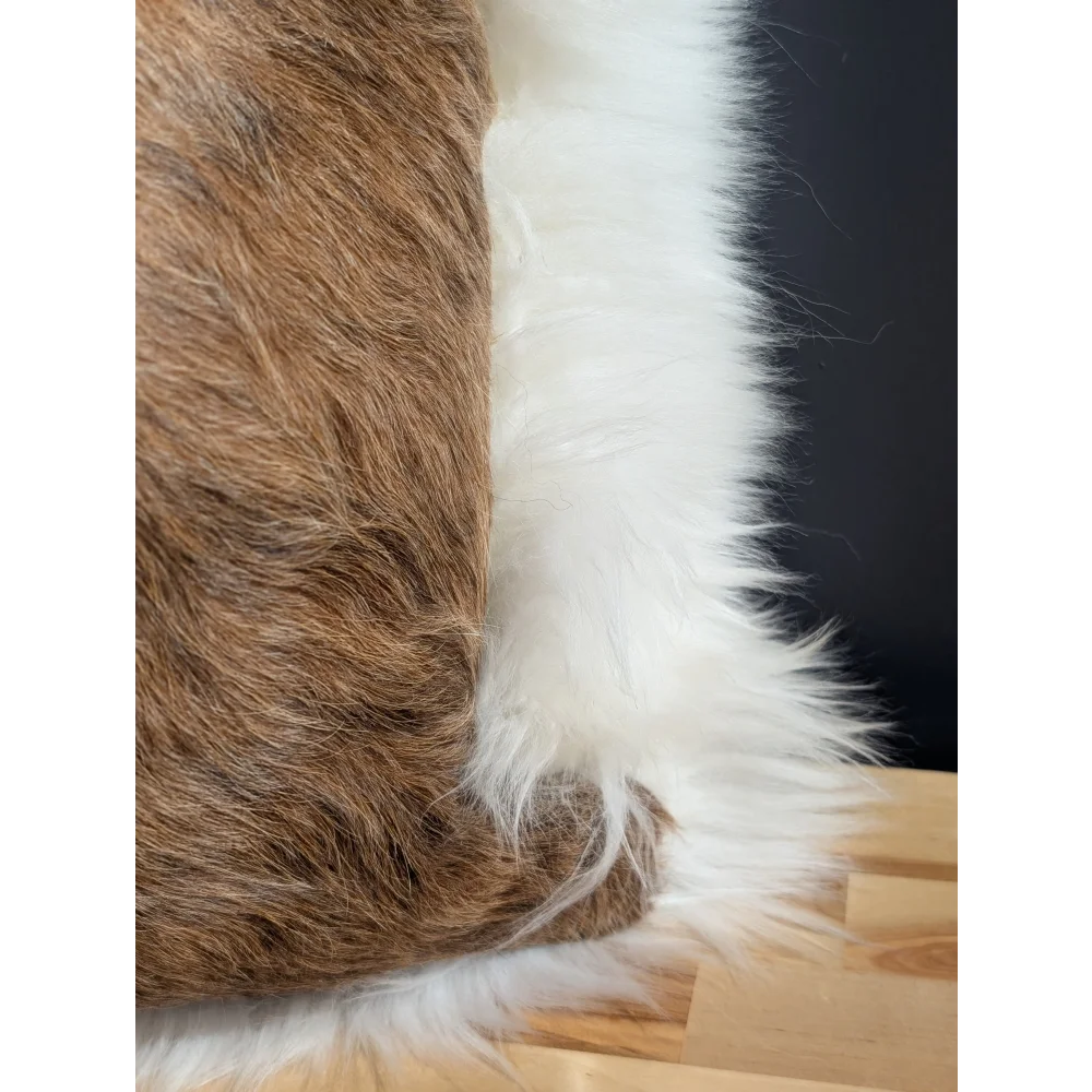 Brown and white faux fur cowhide merino sheepskin cushion with plush textured surface for cozy decor