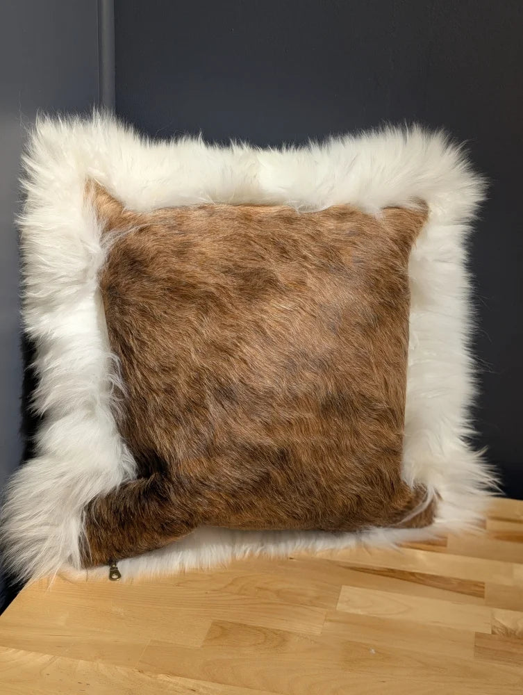 Brown and white cowhide merino sheepskin cushion with plush textured faux fur surface perfect for cozy decor