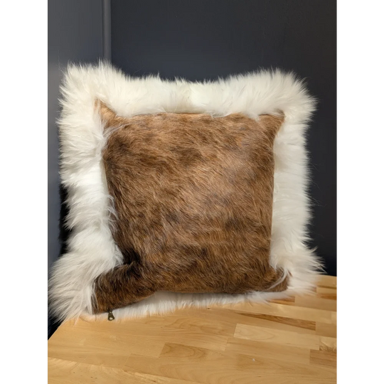 Brown and white cowhide merino sheepskin cushion with plush textured faux fur surface perfect for cozy decor