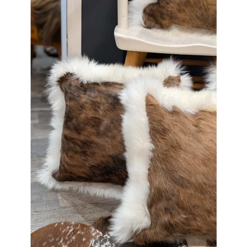 Brown and white cowhide merino sheepskin cushion with fluffy fur trim perfect for cozy home decor