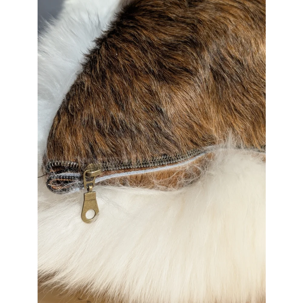 Brown faux fur merino sheepskin cushion with white fluffy trim and metallic zipper in cowhide merino sheepskin style