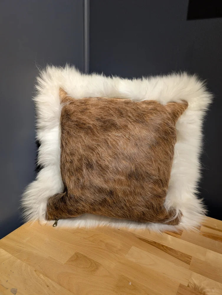 A cozy square cowhide merino sheepskin cushion with brown fur center and plush white faux-fur border