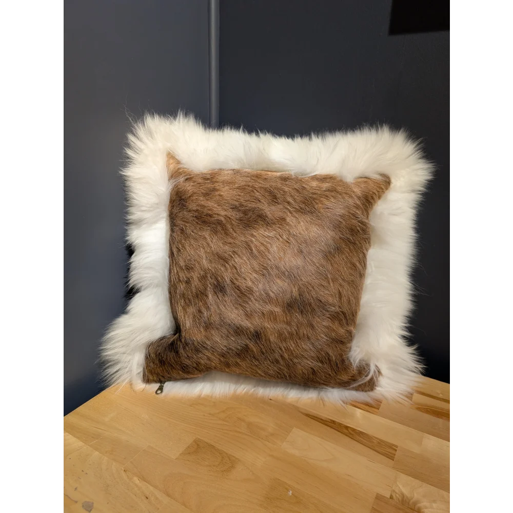 A cozy square cowhide merino sheepskin cushion with brown fur center and plush white faux-fur border