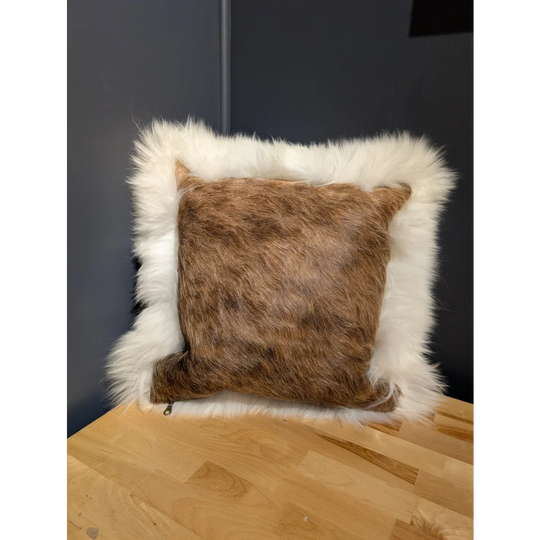 A cozy square cowhide merino sheepskin cushion with brown fur center and plush white faux-fur border