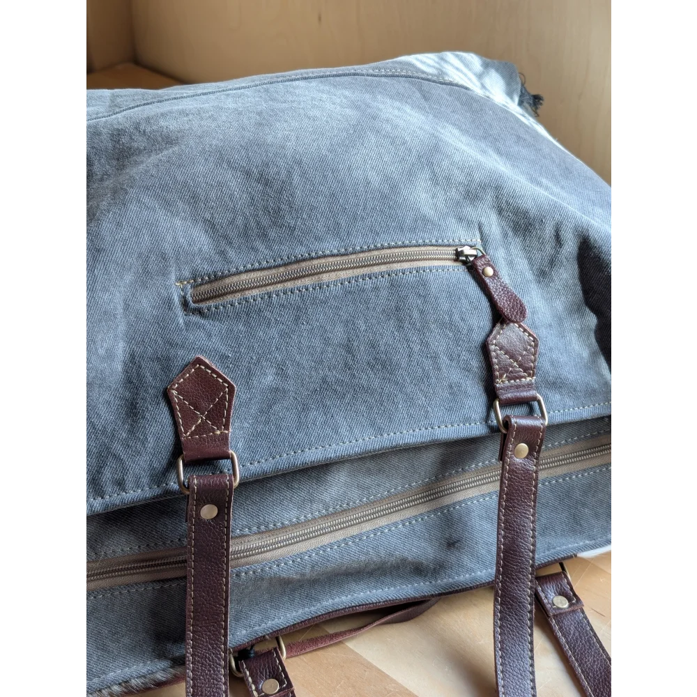 Blue denim sunflower weekender bag with brown leather straps and zippered pocket inspired by cartwright hand-tooled bag
