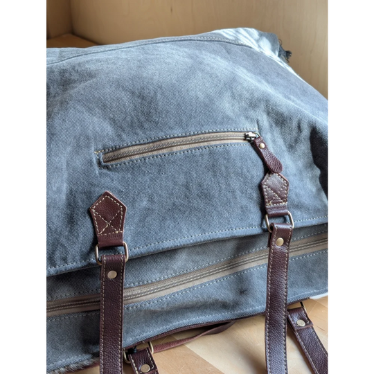 Blue denim sunflower weekender bag with brown leather straps and zippered pocket inspired by cartwright hand-tooled bag