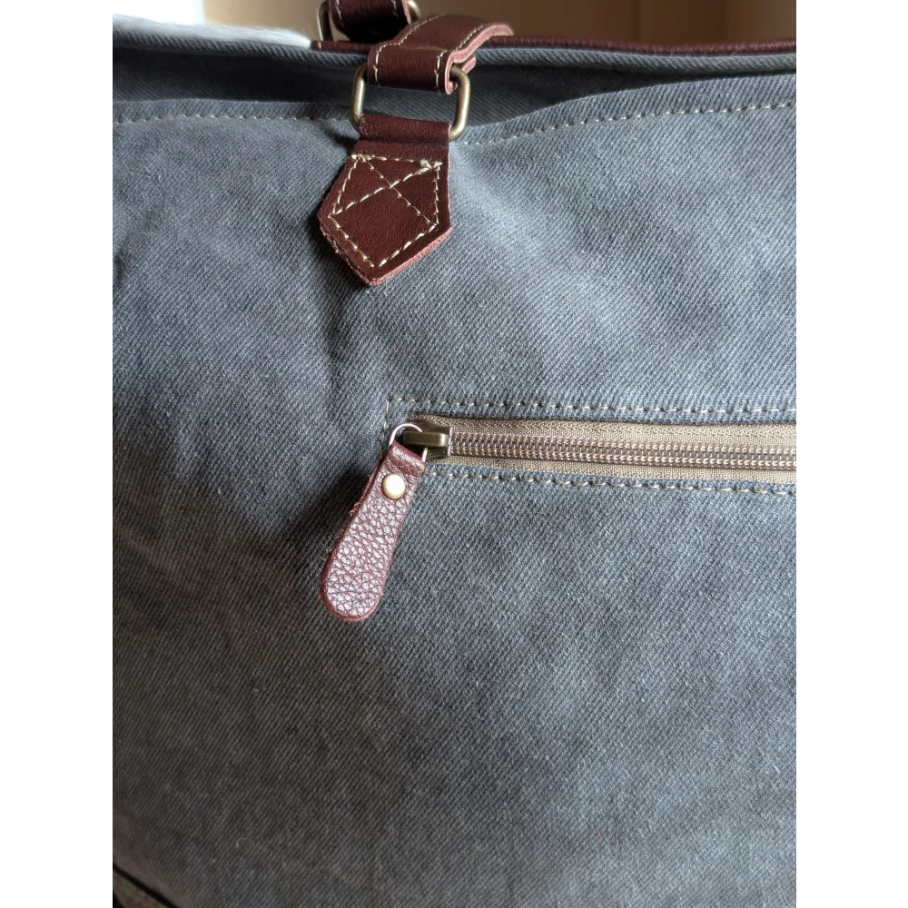 Gray canvas sunflower weekender bag with brown leather accents and zippered pocket perfect for travel use