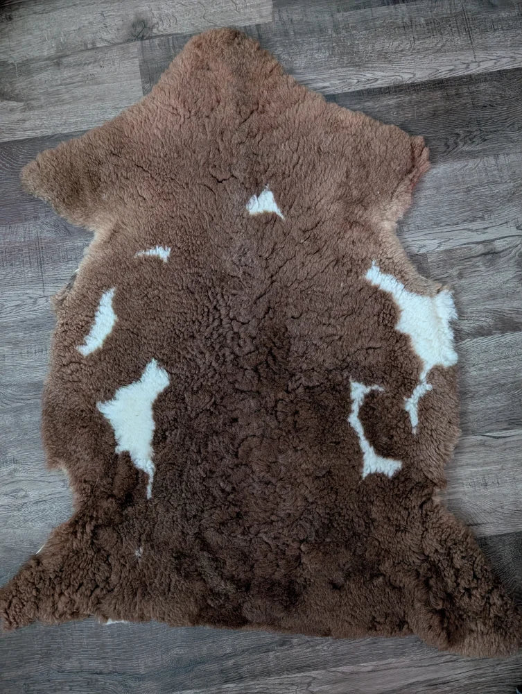 Brown and white tibet highland spotted grade a- sheepskin rug with a plush textured surface from nat’s grade