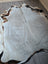 Large cowhide rug with soft gray center and bold black white brown edges perfect for cozy living spaces