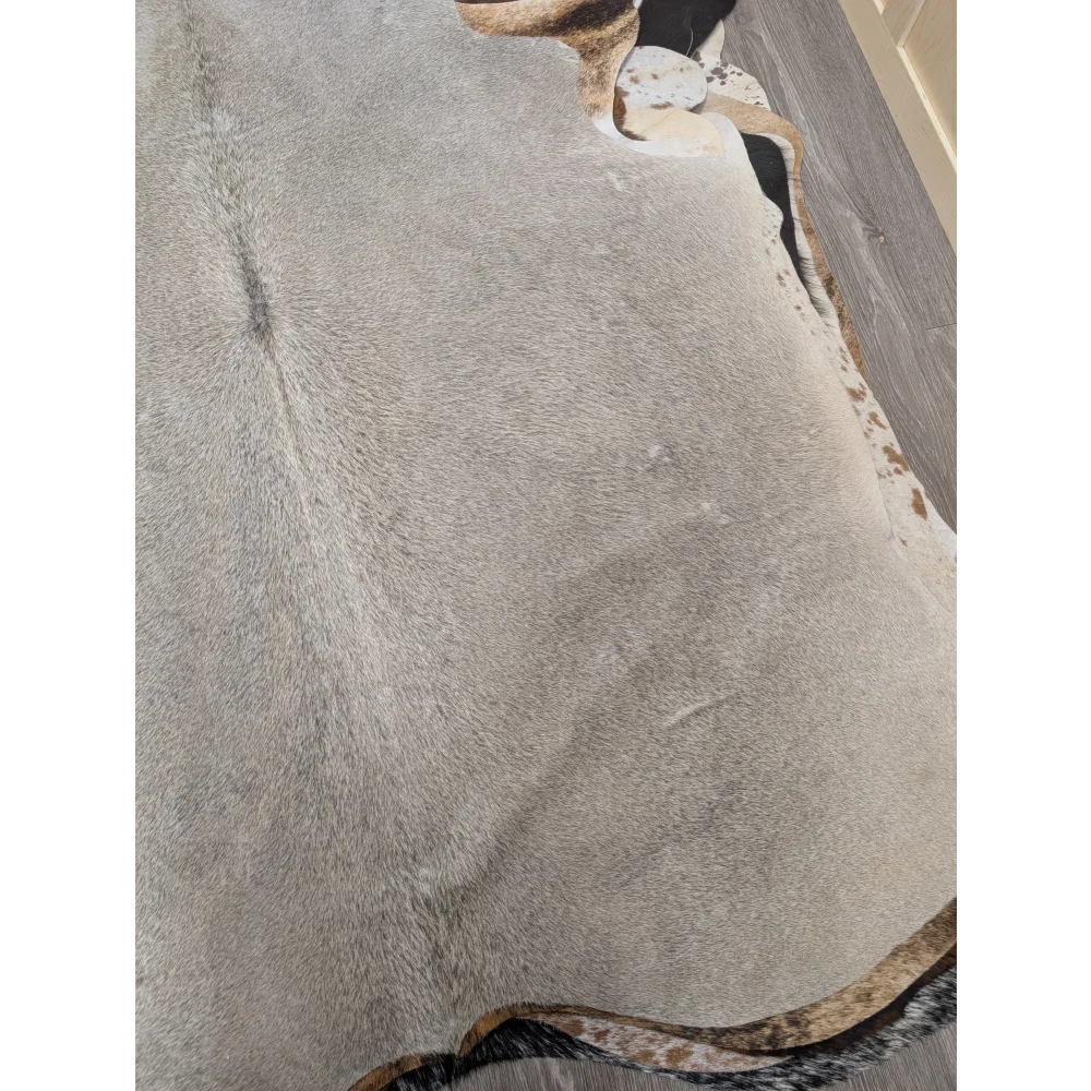 Large gray cowhide rug with natural edges and subtle brown speckles in a lovely cowhide 77.5 by 66 inches