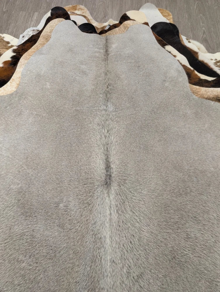 Large lovely cowhide rug gray with textured surface and distinctive black and white patterned border 77.5 x 66 inches