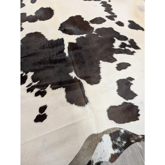 Large lovely cowhide rug with soft fur texture in black and white spotted pattern measuring 77 x 64 inches