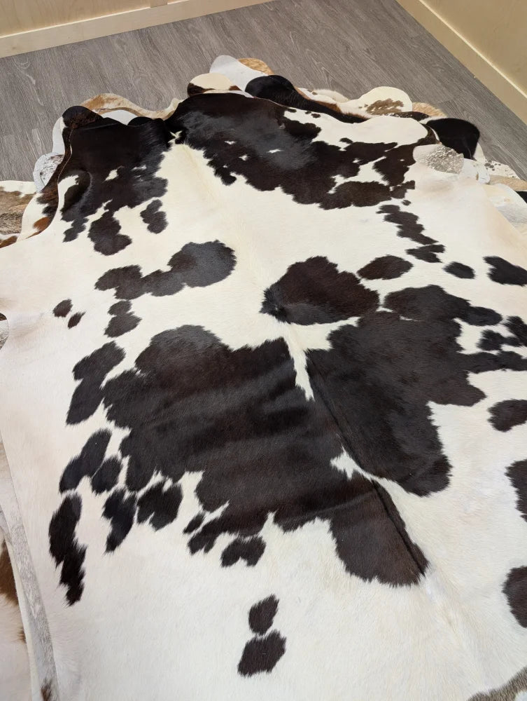 Large lovely cowhide rug 77 x 64 with black and white pattern and natural irregular edges perfect for home decor