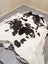 Large lovely cowhide rug with natural irregular shape and striking black and white spotted pattern 77 x 64 inches