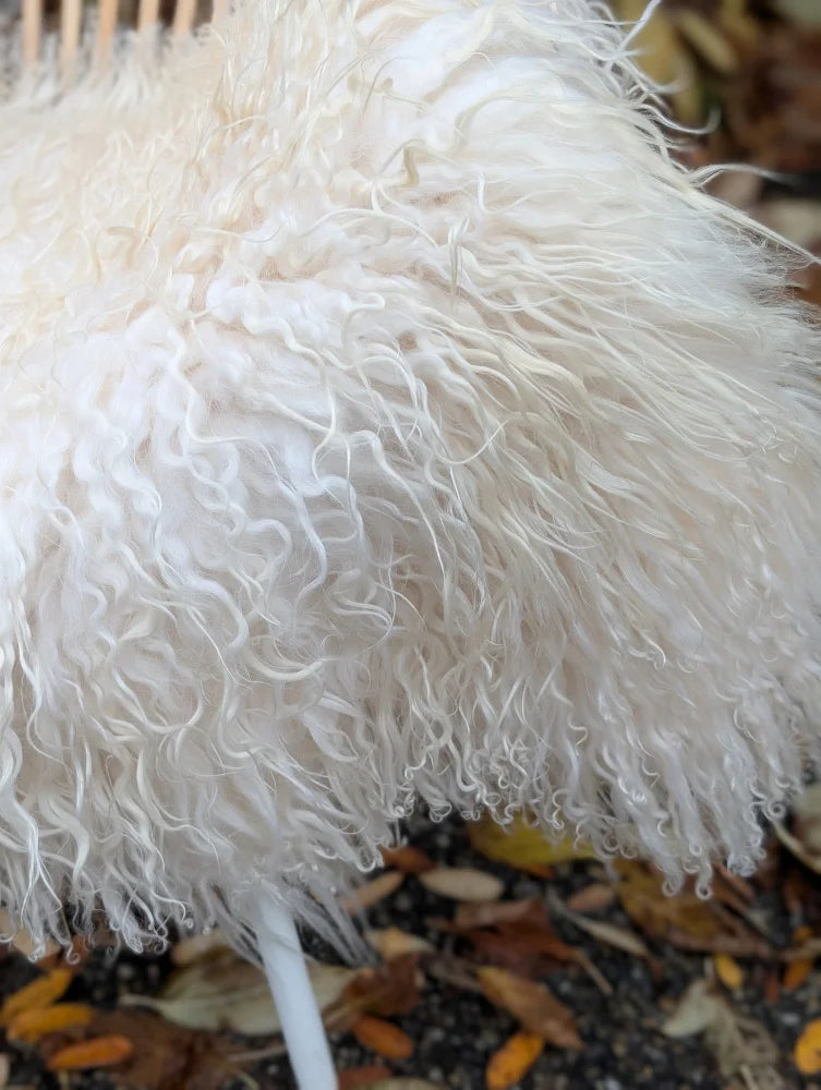 A fluffy natural white icelandic sheepskin decorative umbrella with long wool curly fur