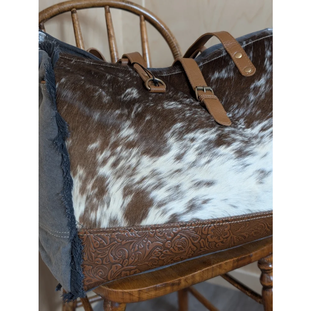 Brown and white cowhide tote bag with tan leather straps and embossed brown leather base from matty affair canvas