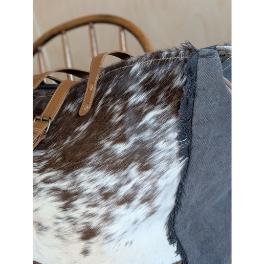 Brown and white cowhide shoulder bag with tan leather straps from angus oliver matty affair canvas weekender bag