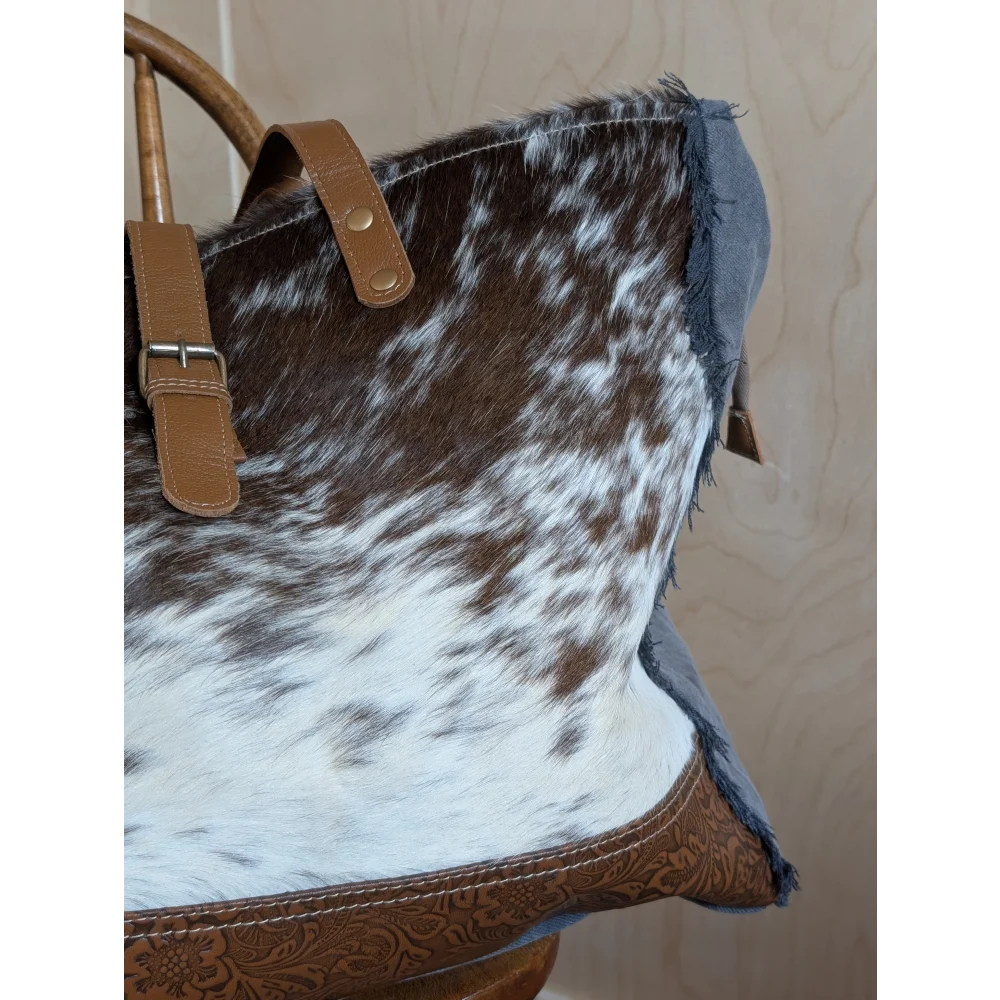Brown and white cowhide tote bag with tan leather handles and decorative stitching from matty affair canvas collection