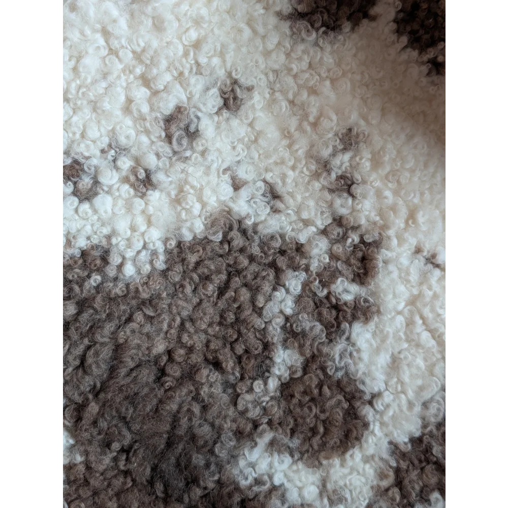Cream and brown curly wool blanket made from grade a- highland spotted sheepskin with a soft plush texture