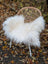 Natural white icelandic sheepskin long wool throw draped over woven wicker chair with white metal legs