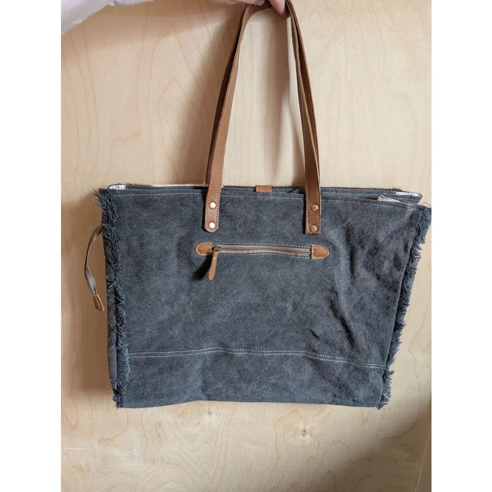 Gray matty affair canvas weekender bag with frayed edges tan leather handles and zipper accents by angus oliver