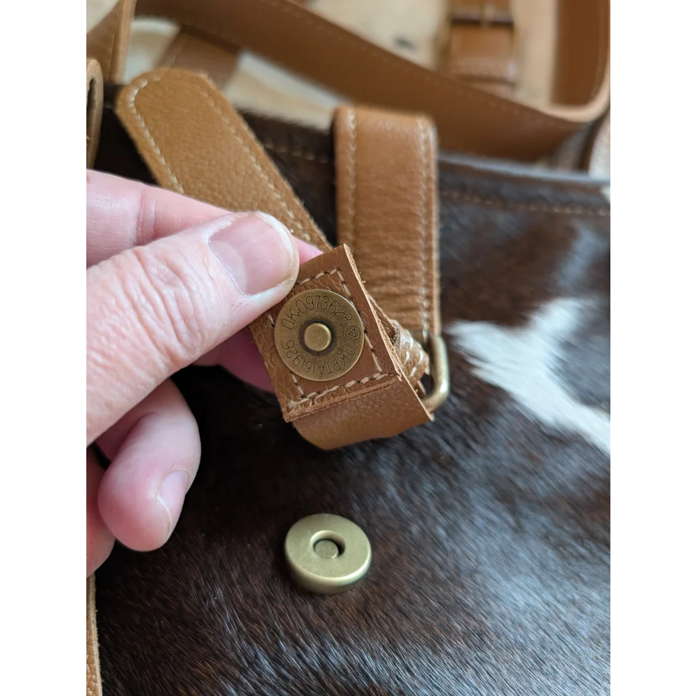 Tan leather strap with brass magnetic snap closure on the 