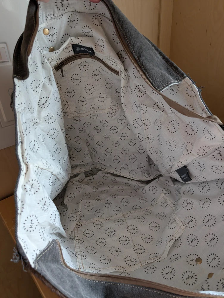 White canvas tote bag with black circular pattern, denim accents, and brown leather trim from matty affair canvas by angus oliver