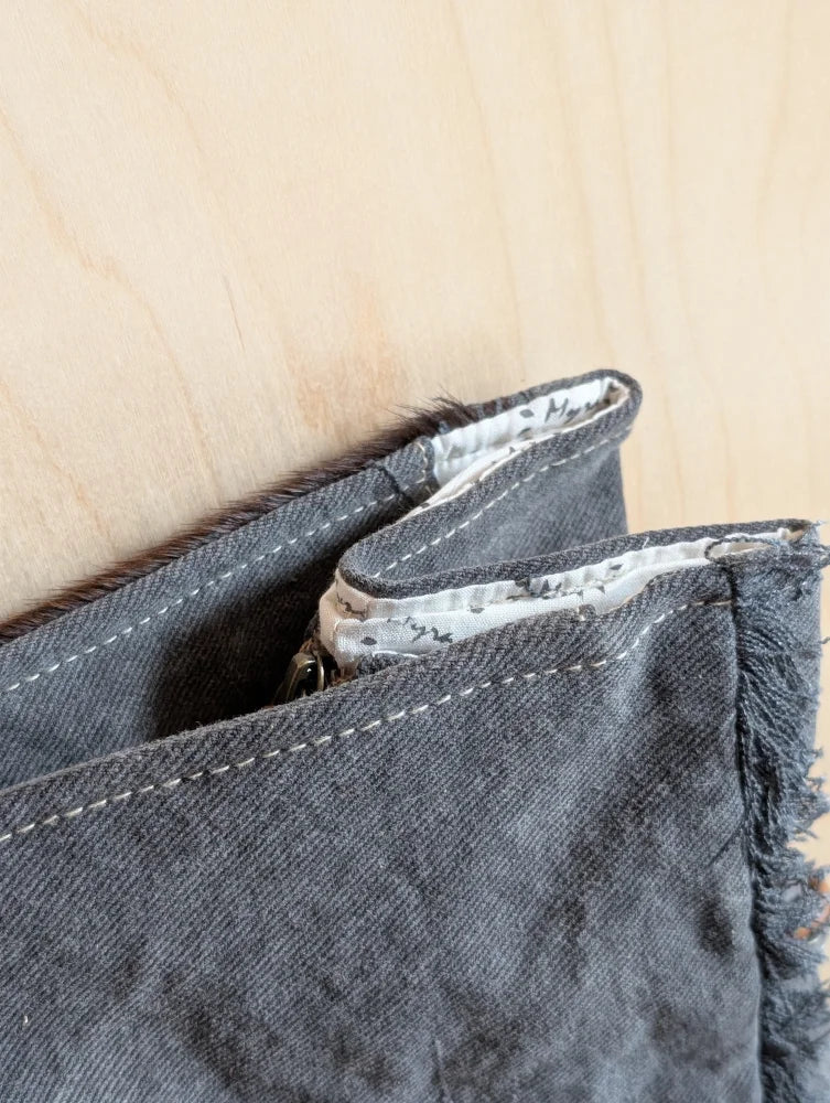 Dark gray denim wallet with frayed edges and zipper pull from the matty affair canvas and angus oliver collection